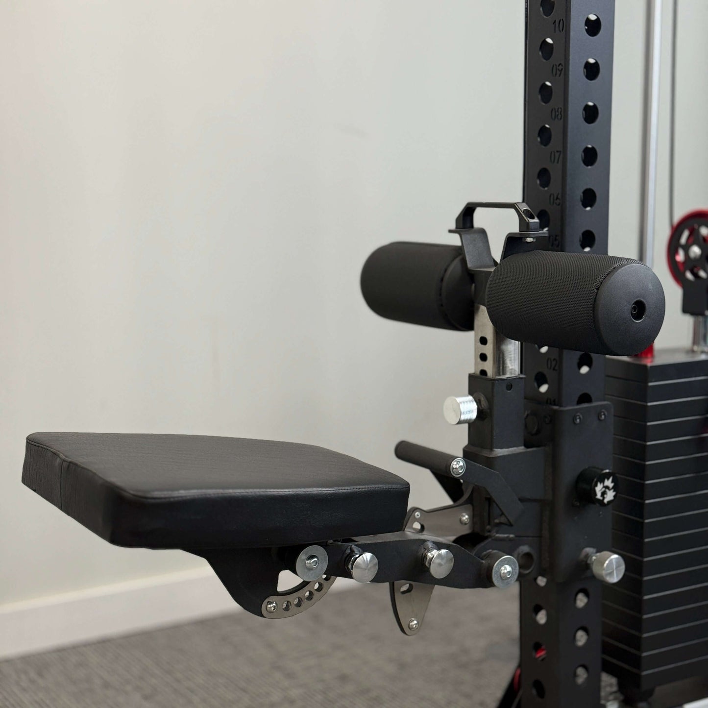Spartaks Strength Pegasus Bench Rack Attachment showing padded seat and support mechanism in a gym.