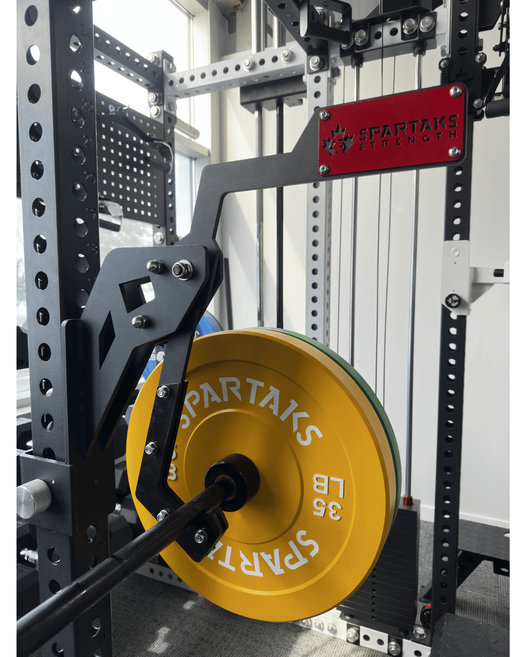 Spartaks Strength Adjustable Monolift Rack Attachment with weight plates and robust design for home gym setup in Canada.